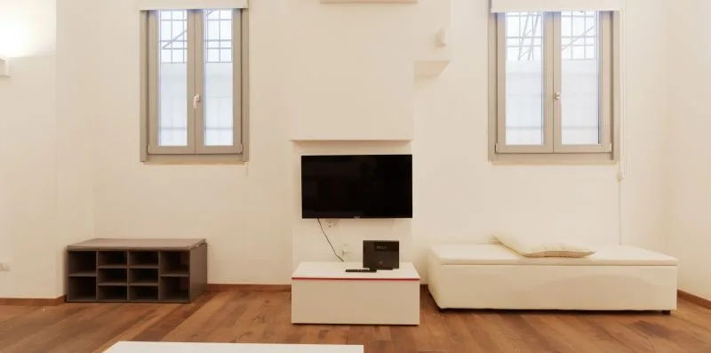 A bright living room with a television, low cabinet, and seating.