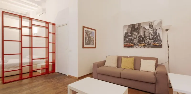 A living room with a sofa, a coffee table, and framed wall art.