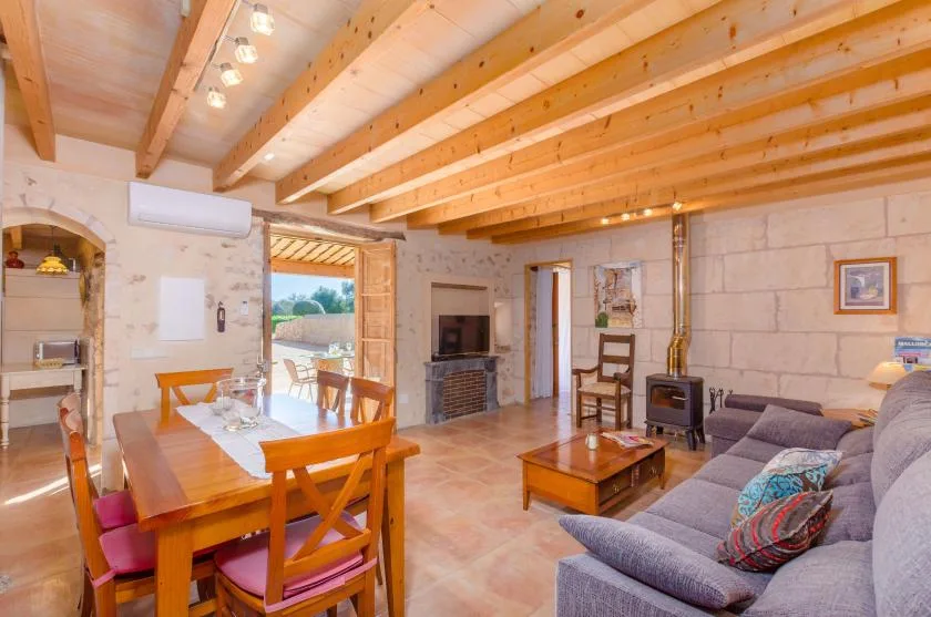 Una sala de estar y comedor con una mesa de comedor de madera y asientos.