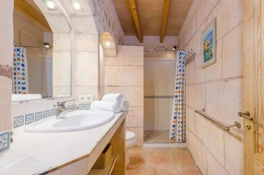 Un baño con lavabo, espejo y zona de ducha.