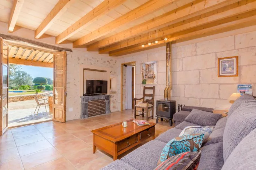 Una sala de estar con asientos, una mesa de centro y un techo con vigas de madera.