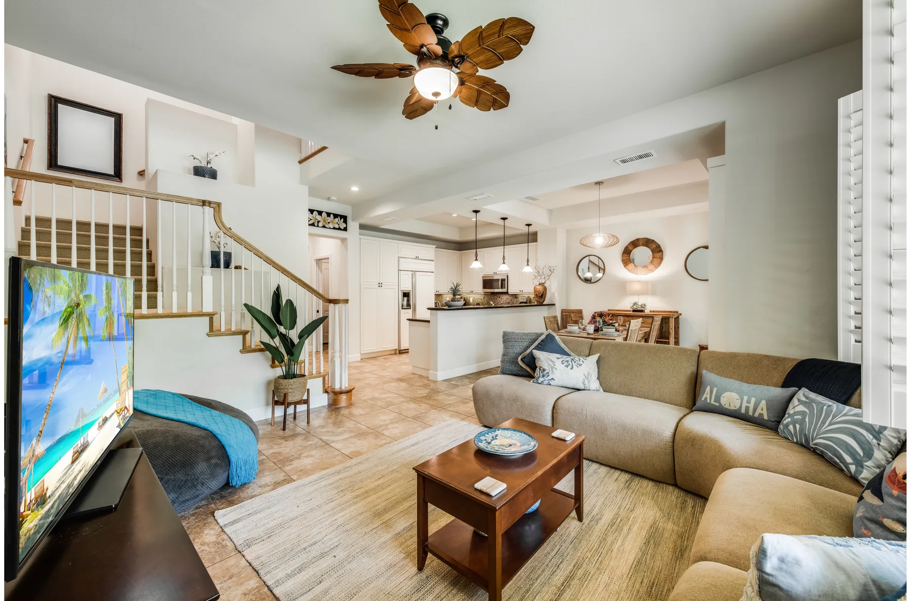 A living room with seating, a coffee table, and an open kitchen beyond.