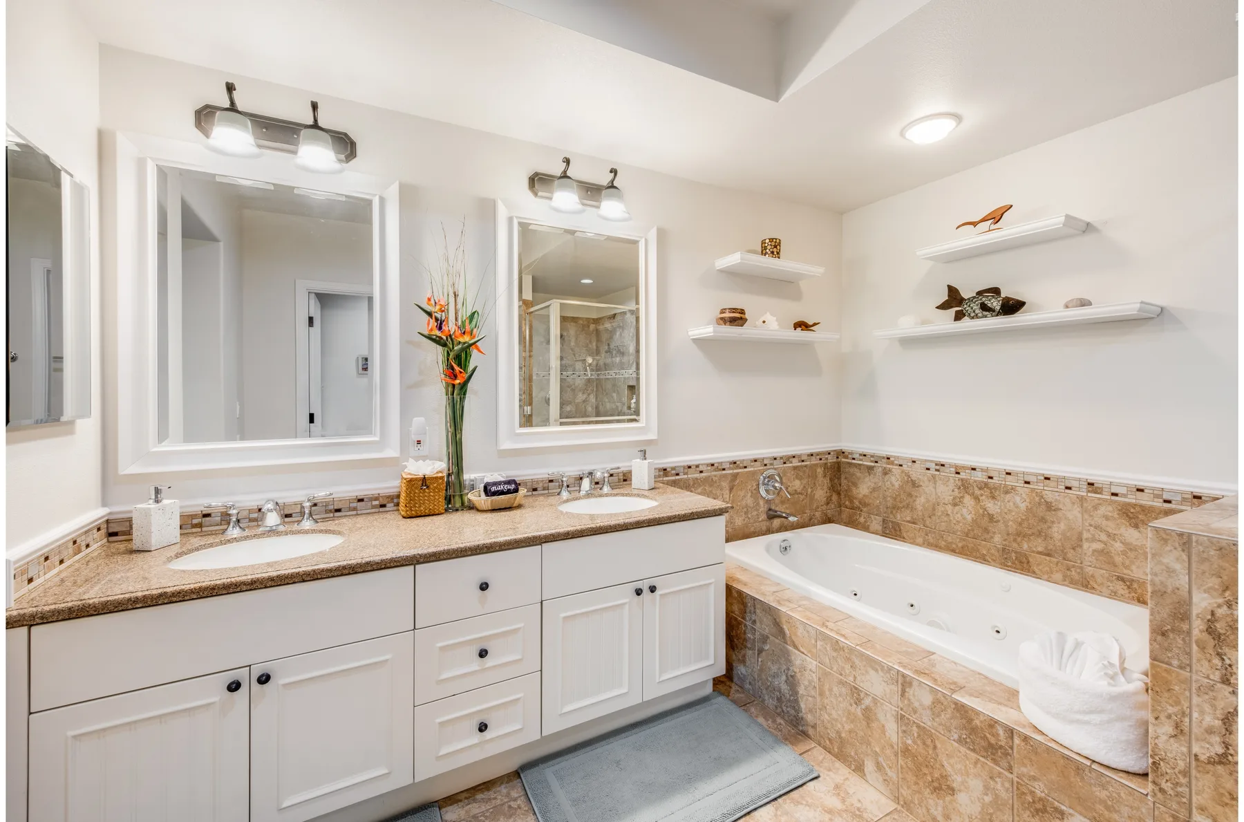 A bathroom with a long vanity, two mirrors, and a bathtub.