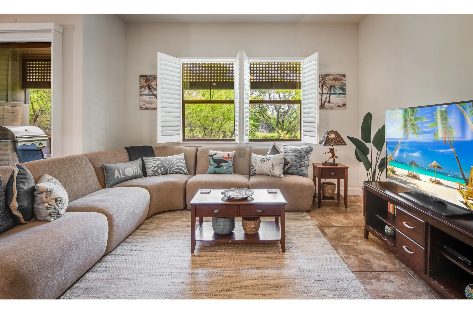 A living room with sectional seating, a coffee table, and a television.