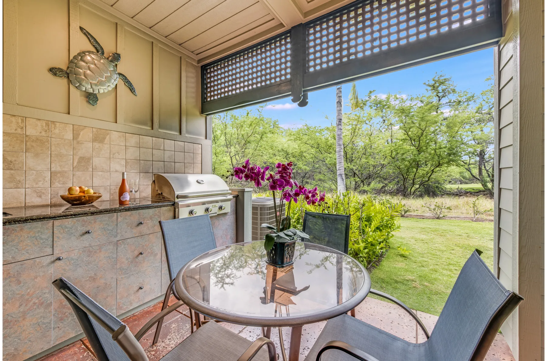 A covered patio dining area opens onto a green garden.