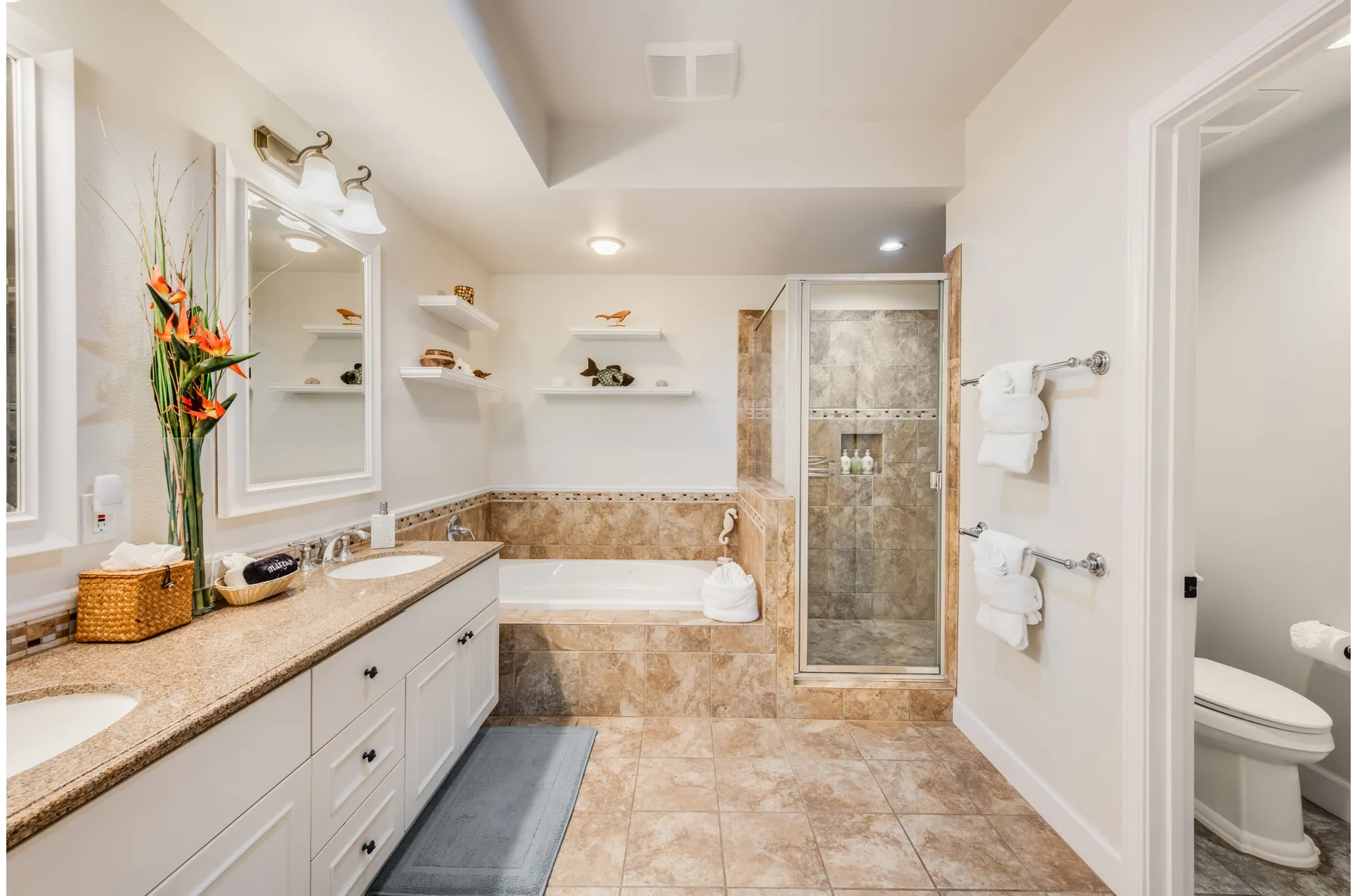 A bathroom with a long vanity, bathtub, and glass shower.