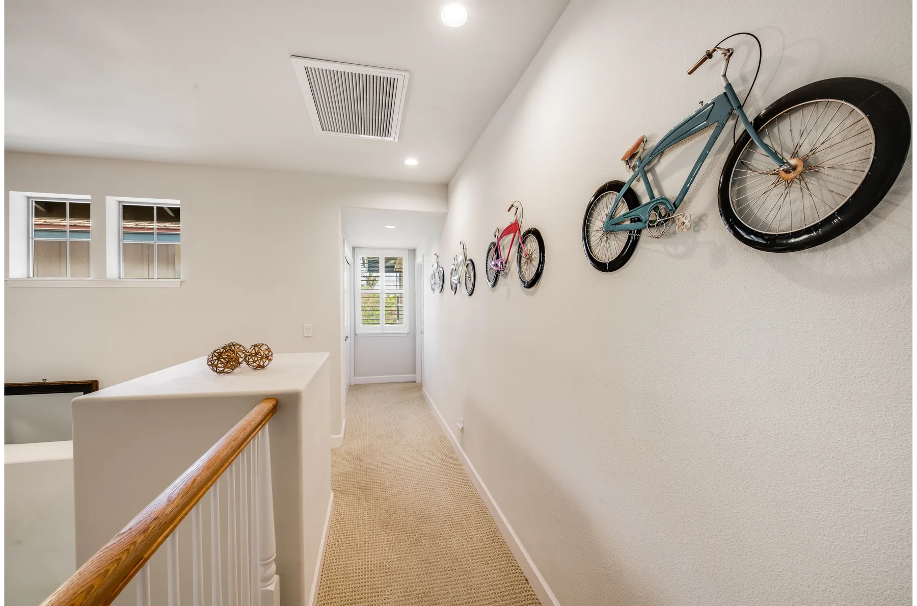 A bright upstairs hallway has bicycles mounted along one wall.