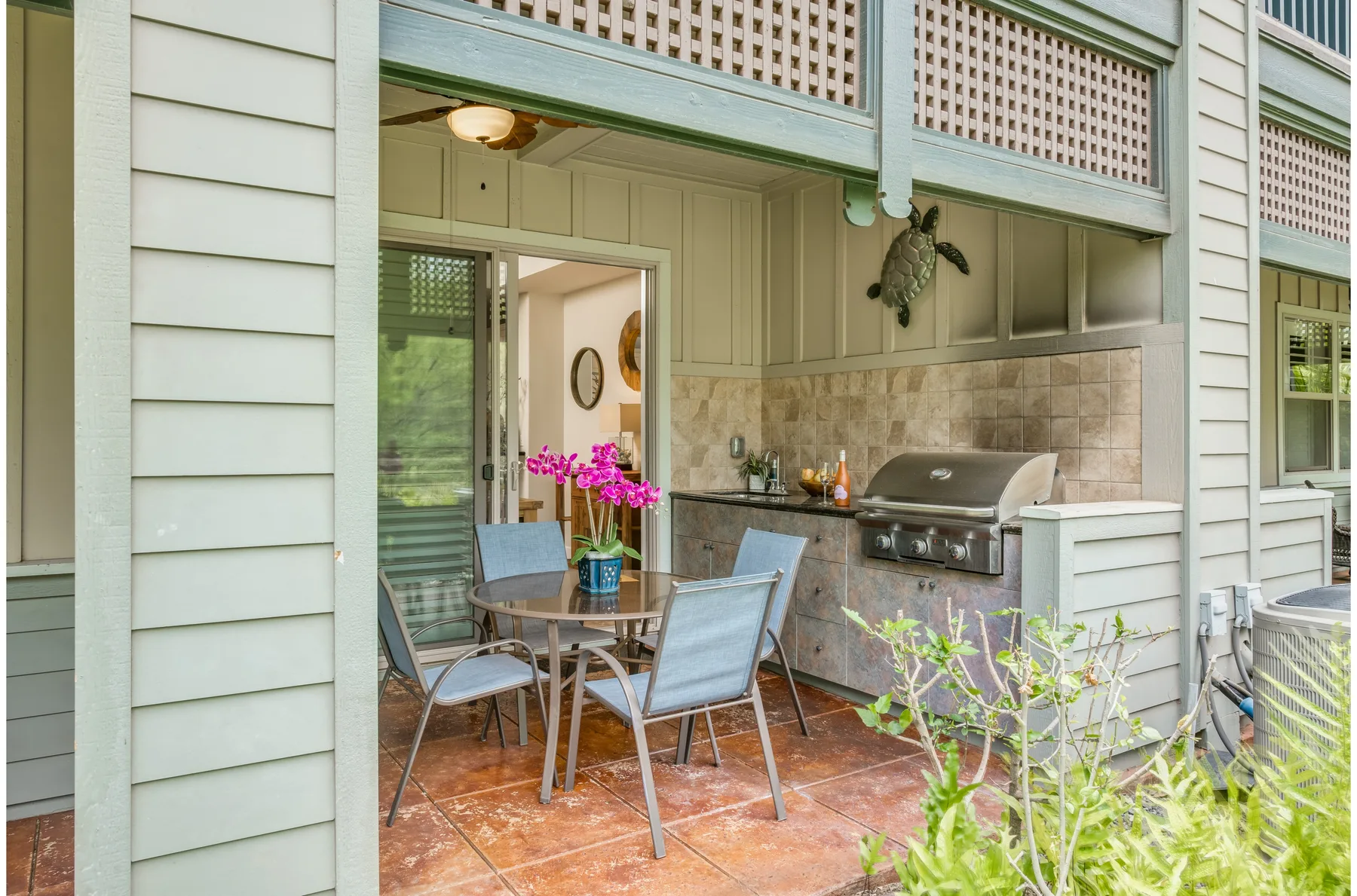 A covered outdoor dining area with a table beside a built-in grill.