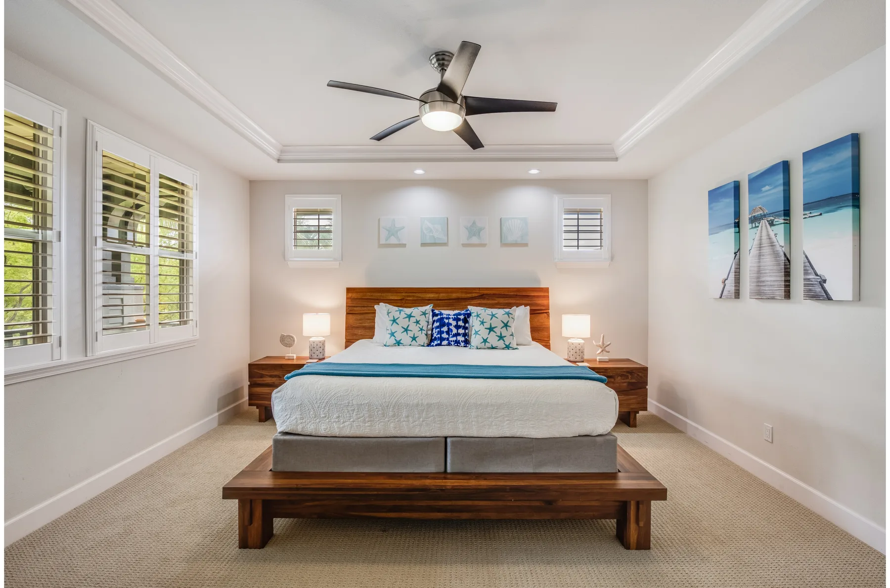 A bright bedroom with a bed centered between matching bedside tables.