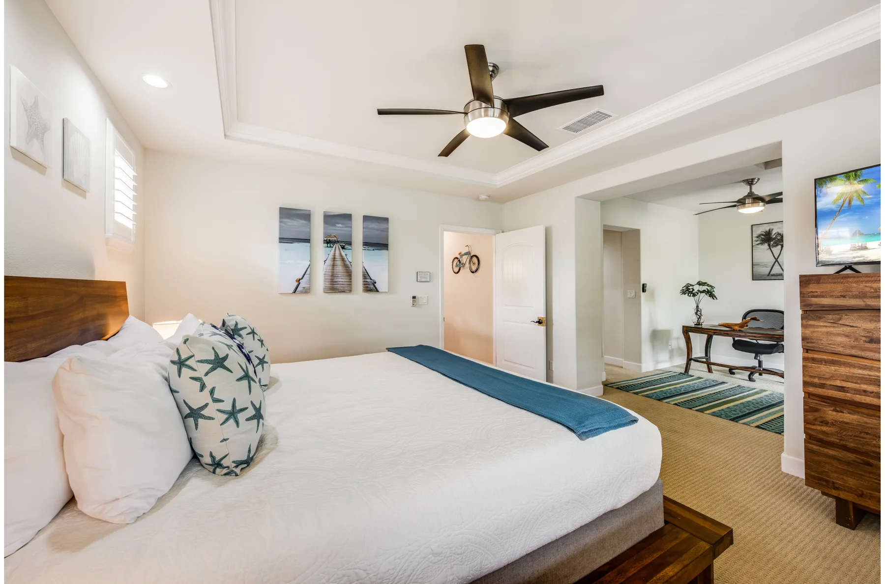 A bright bedroom with a large bed and an adjoining sitting area.