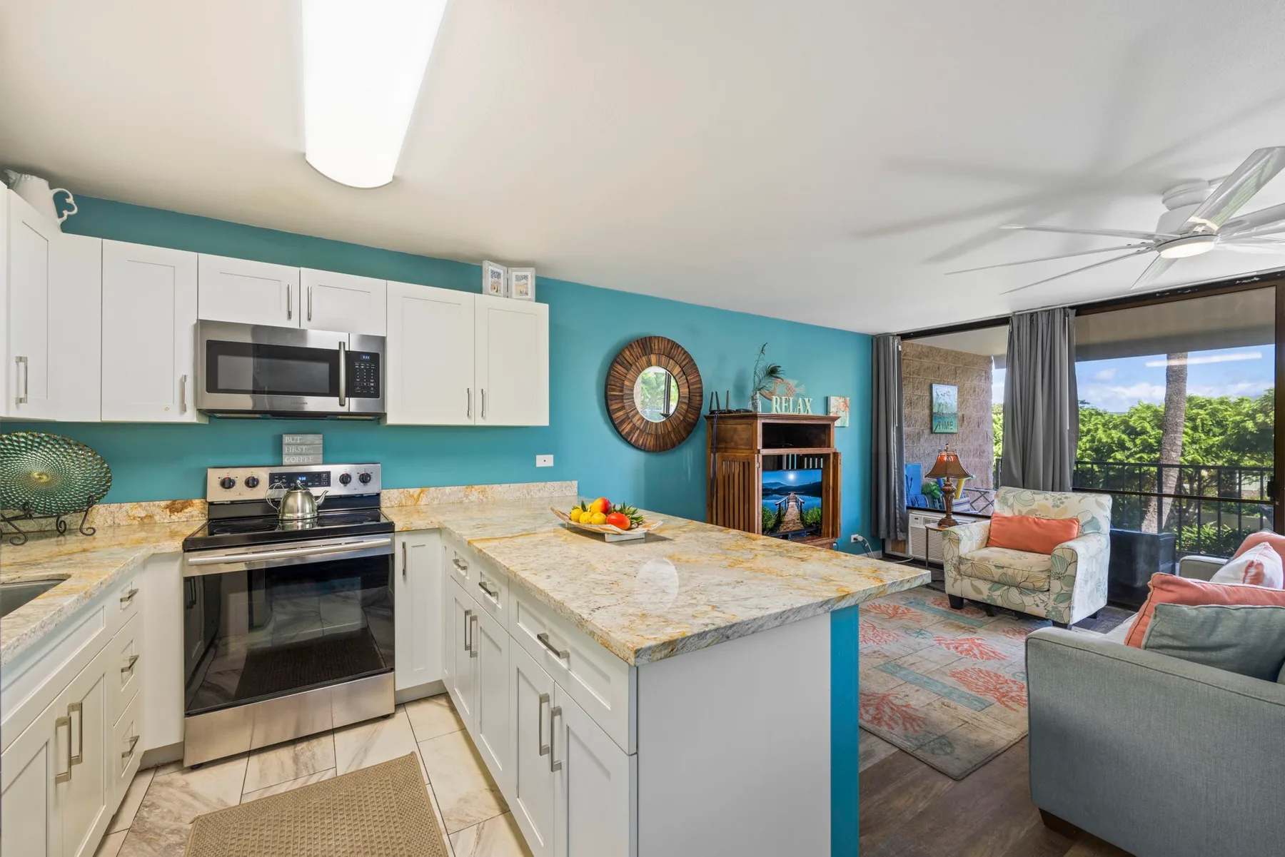 Una cocina abierta y sala de estar con una isla grande y asientos junto a las ventanas.