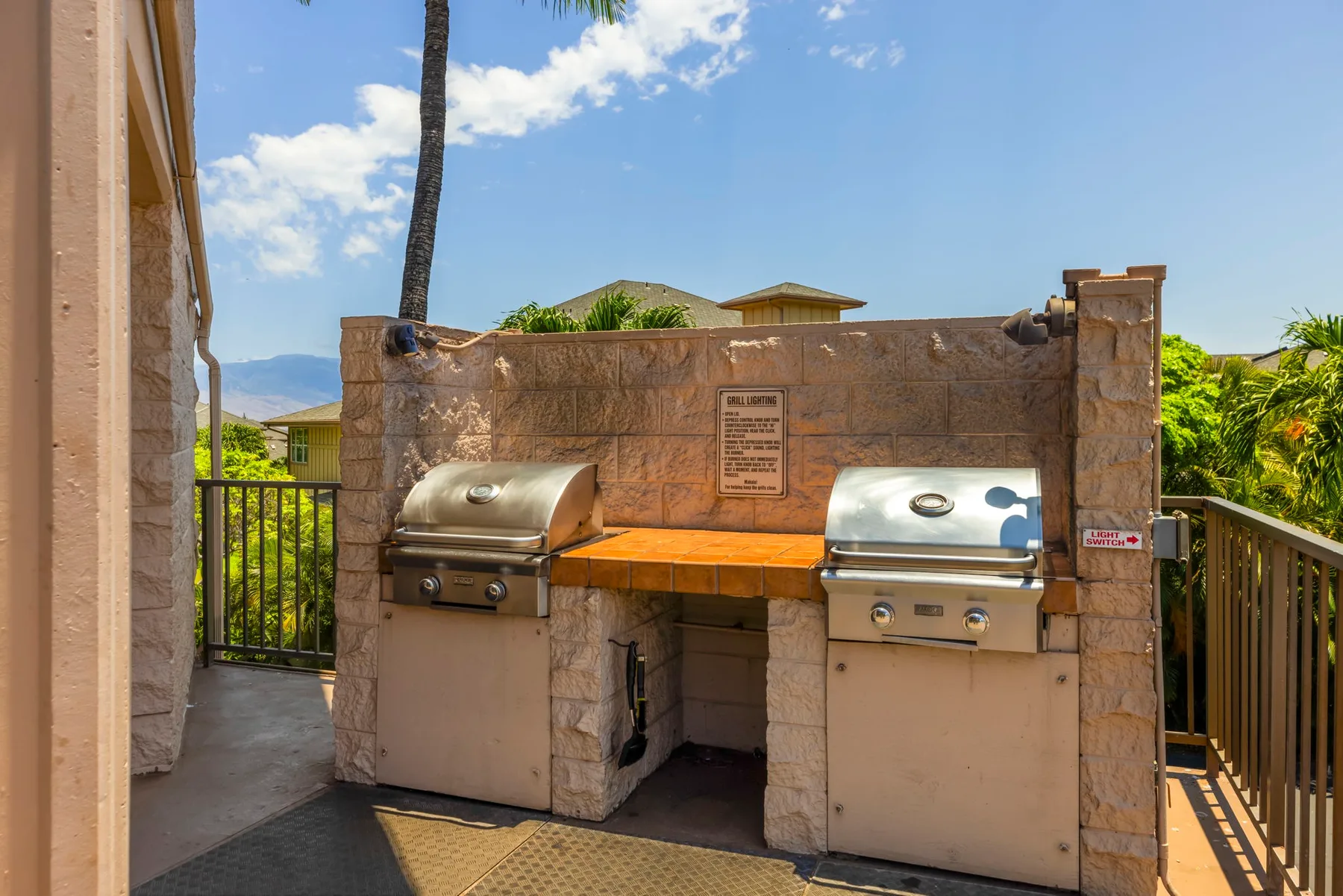 Una zona exterior de parrilla con dos parrillas integradas en un muro de piedra.