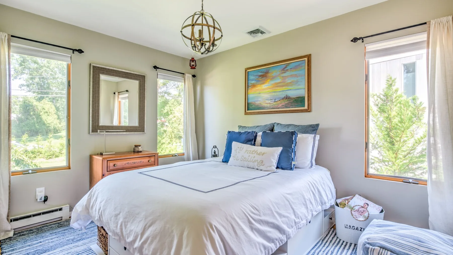 A bright bedroom with a neatly made bed and windows on either side.