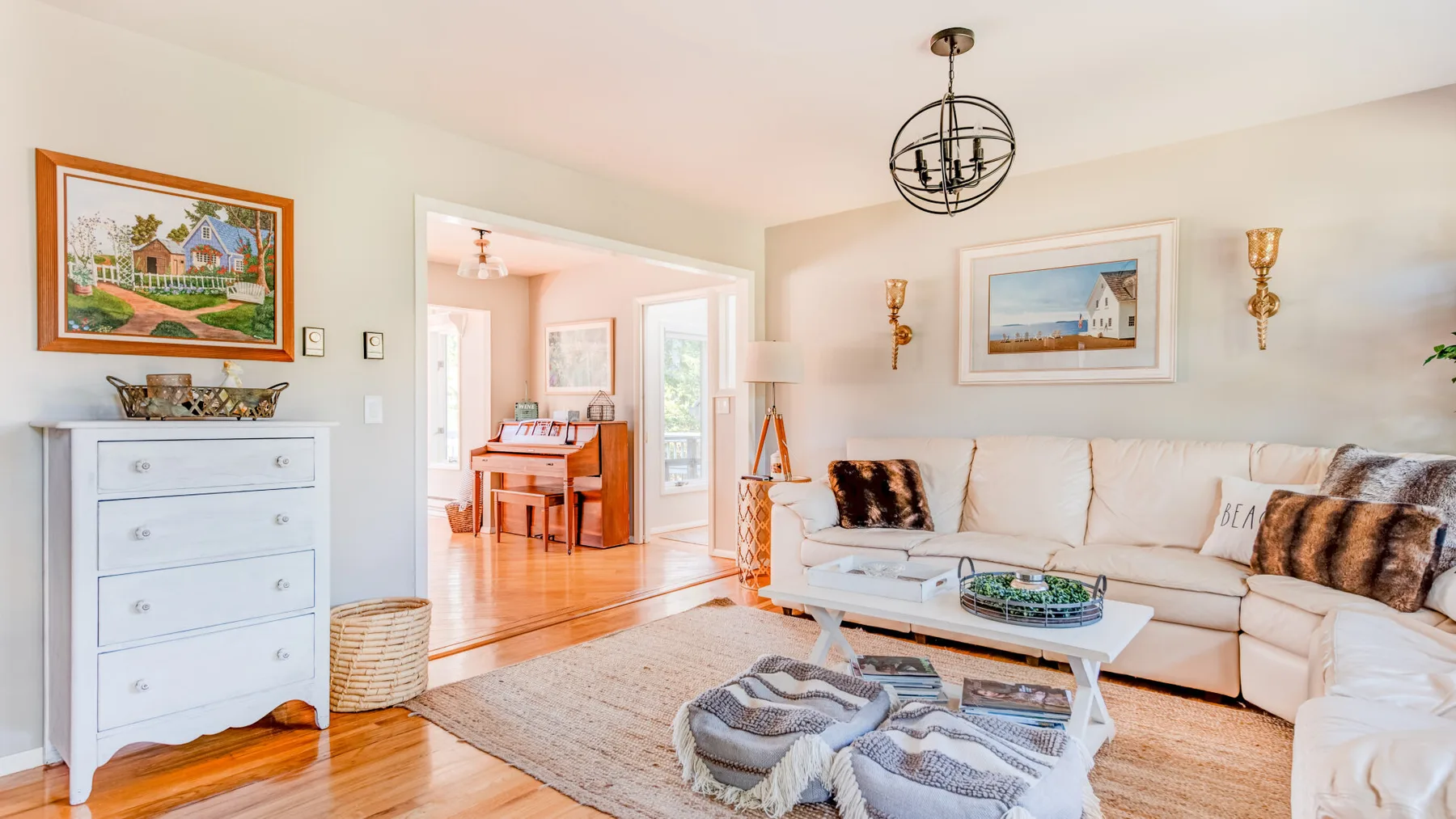A bright living room with a sectional seating area and a white coffee table.