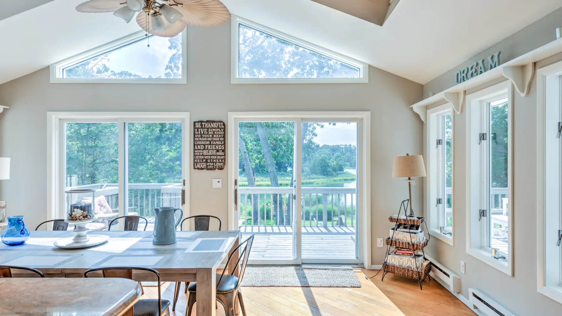 A bright dining area with a table beside large windows and glass doors.