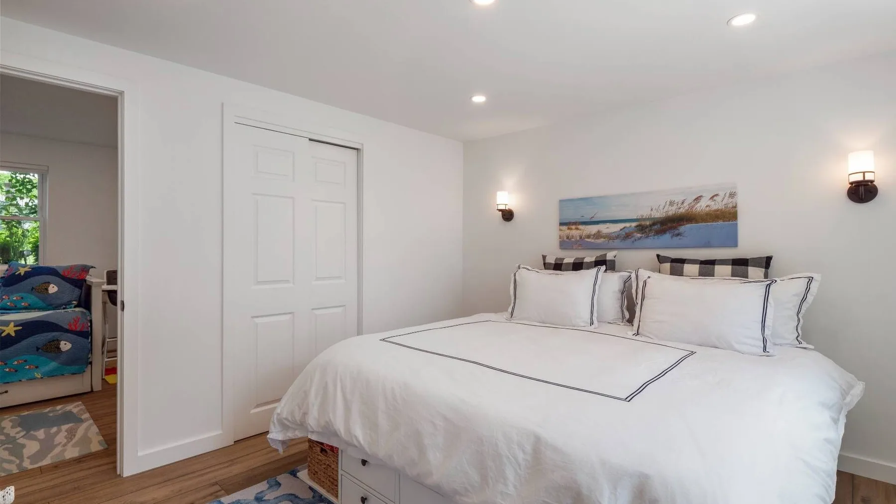 A bedroom with a large bed and white bedding.