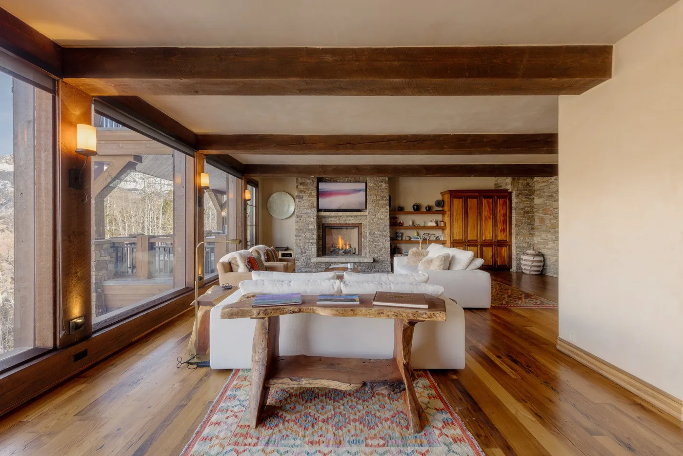 Una sala de estar con asientos alrededor de una mesa baja de madera y una chimenea.