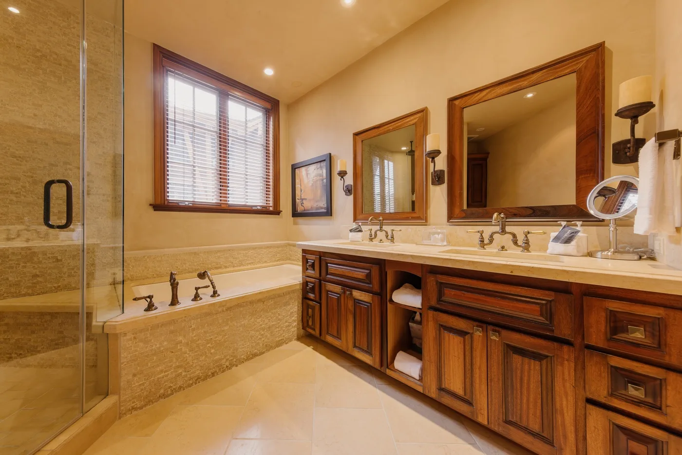 Un baño con un mueble largo, dos lavabos y una bañera empotrada.