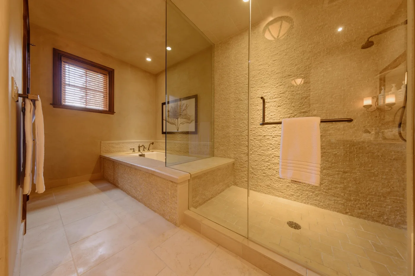 Un baño con bañera junto a una ducha con paneles de vidrio.