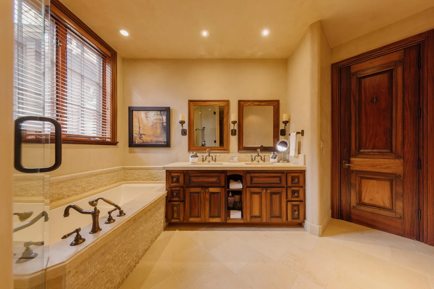 Un baño con bañera, tocador y gabinetes de madera.