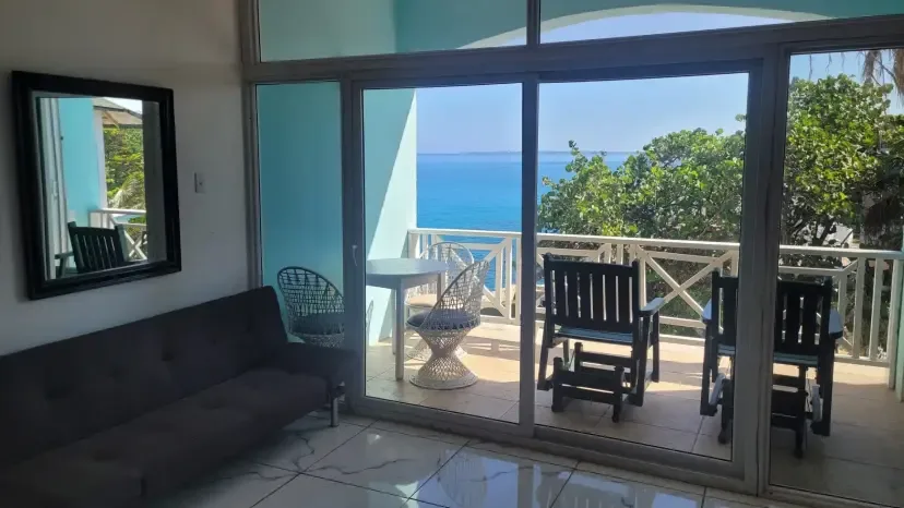 Sala de estar y balcón con vistas al mar en la suite de dos dormitorios, habitación 18