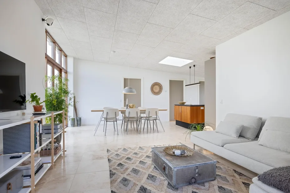 A bright living and dining area with seating, a coffee table, and a dining table.