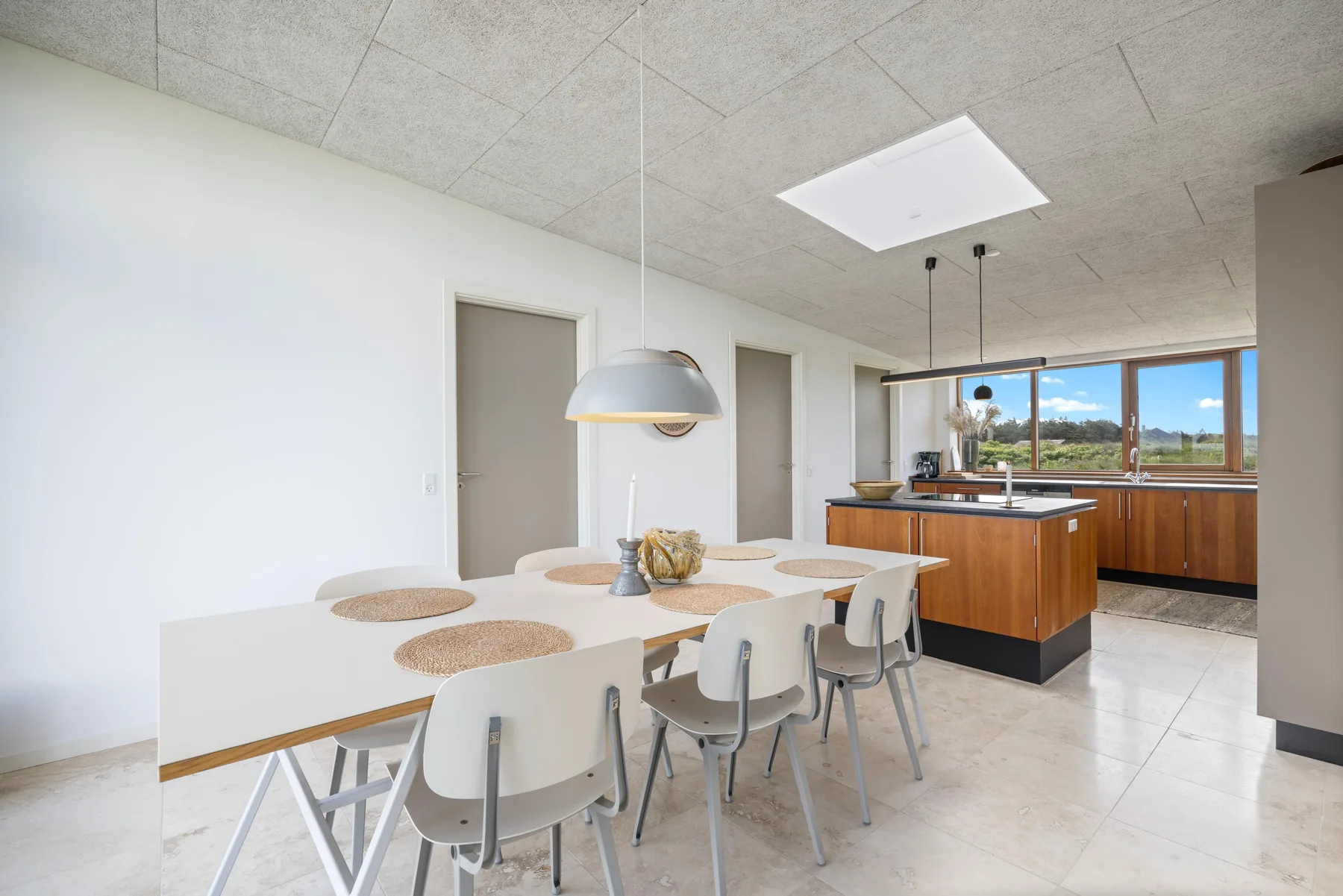 A bright dining area with a table and an open kitchen.