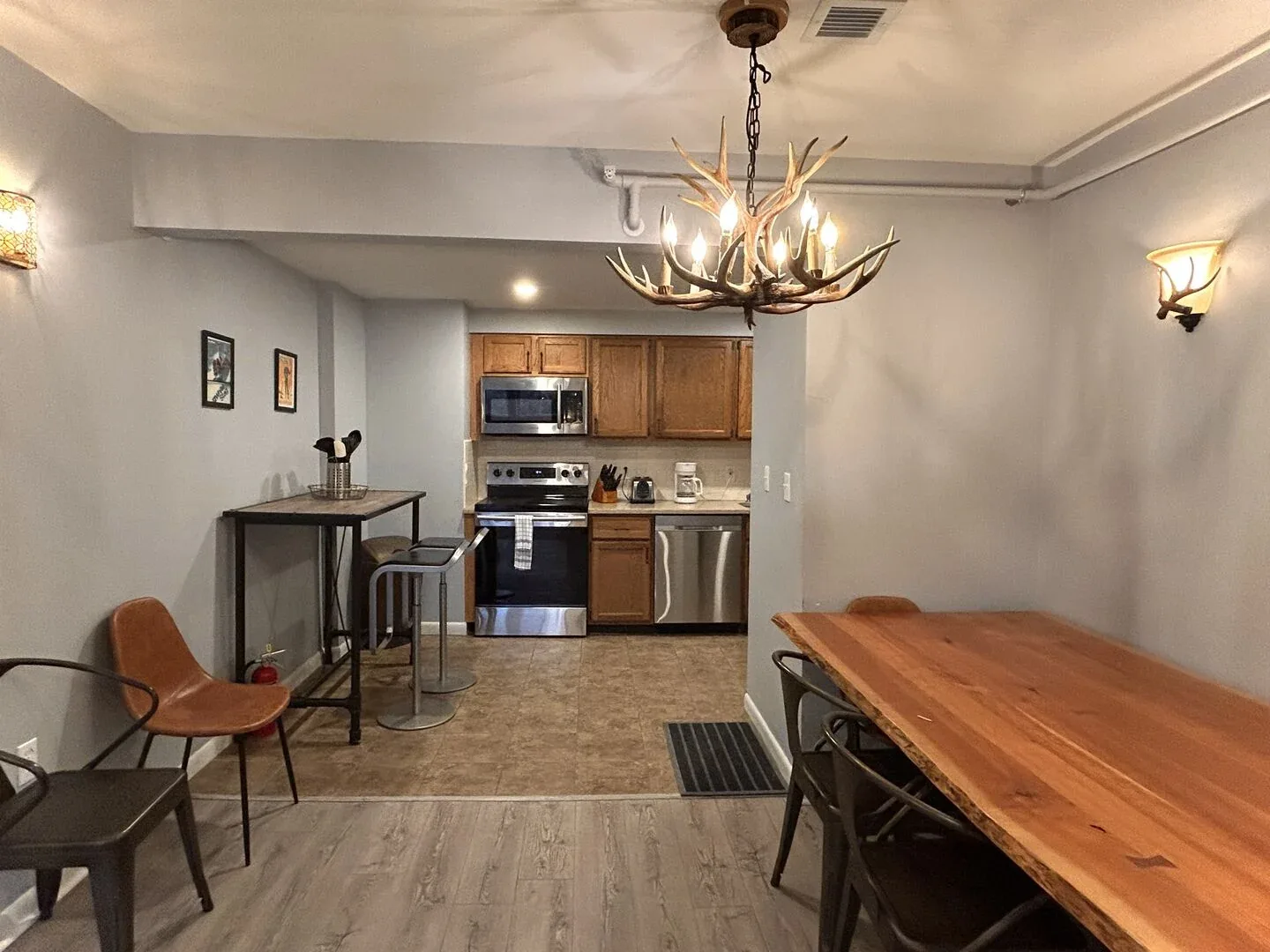 Un comedor abierto con cocina, una mesa larga de madera y gabinetes.