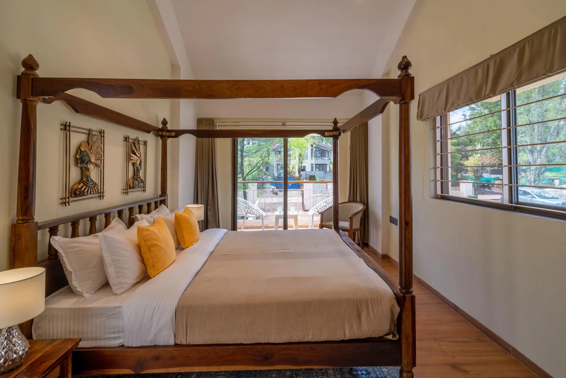 Un dormitorio con una cama con dosel de madera y puertas corredizas de vidrio.