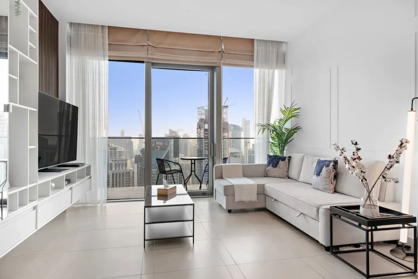 A bright living room with a sectional seating area beside large windows.