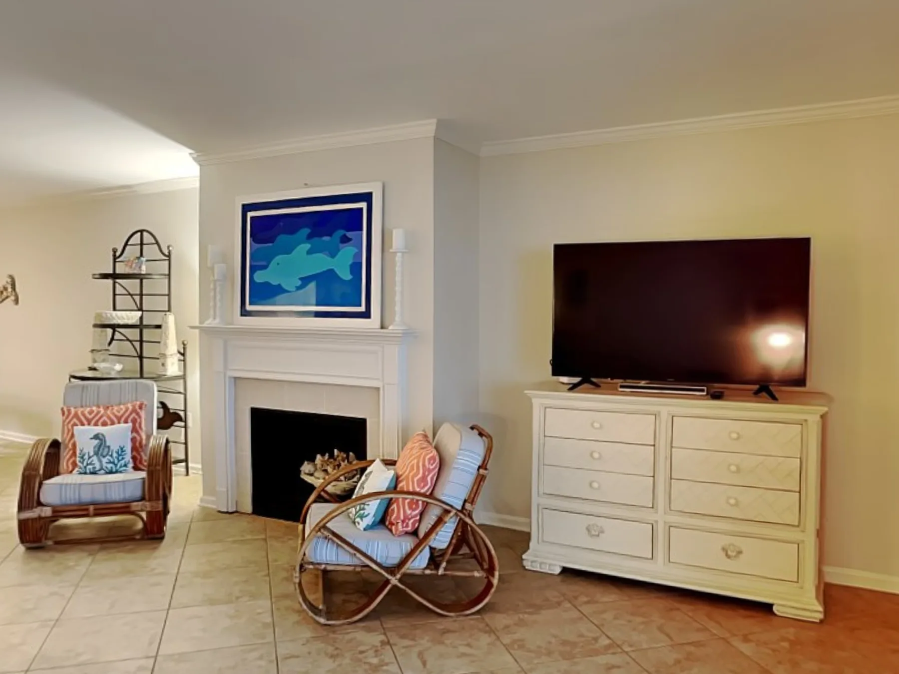 Una sala de estar cuenta con chimenea, televisor y asientos.