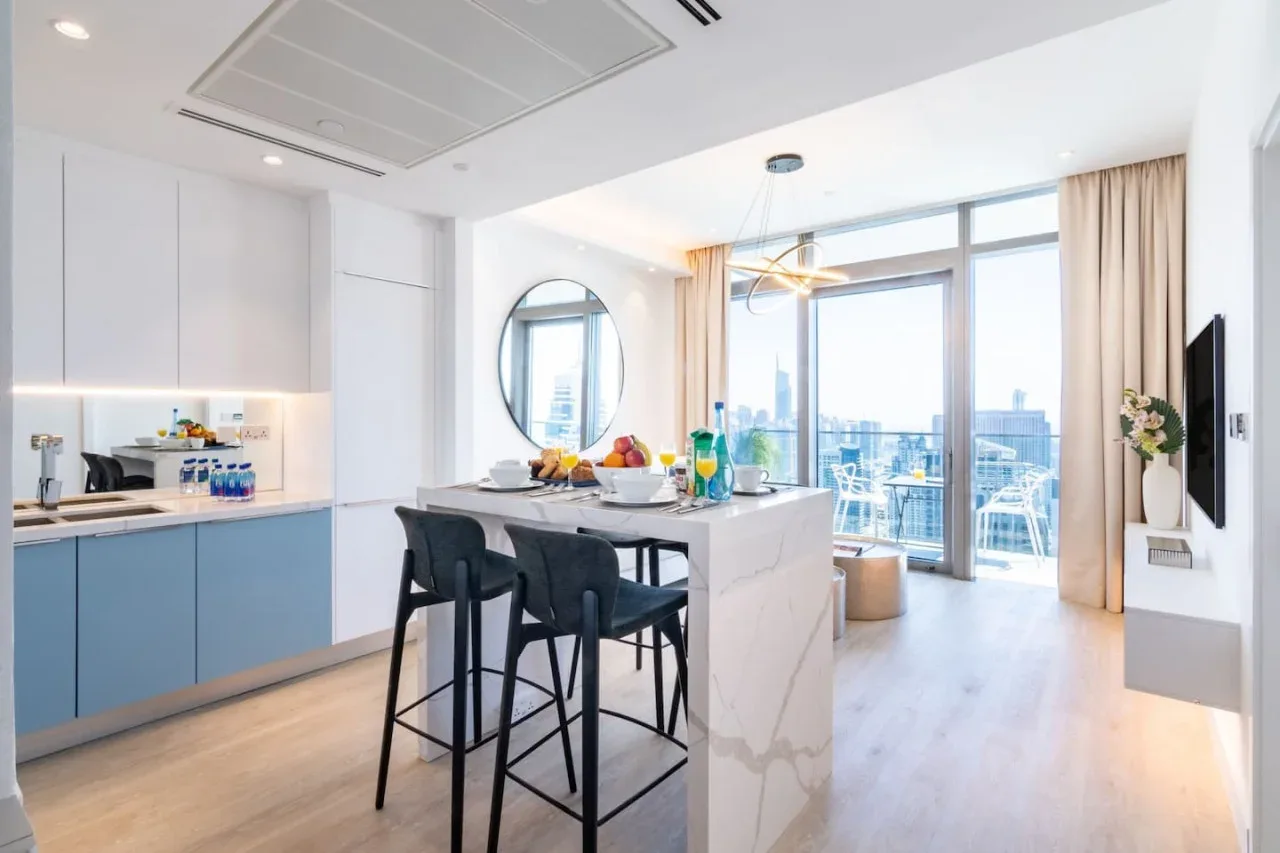 Una luminosa cocina-comedor de planta abierta, con una isla central y puertas al balcón.