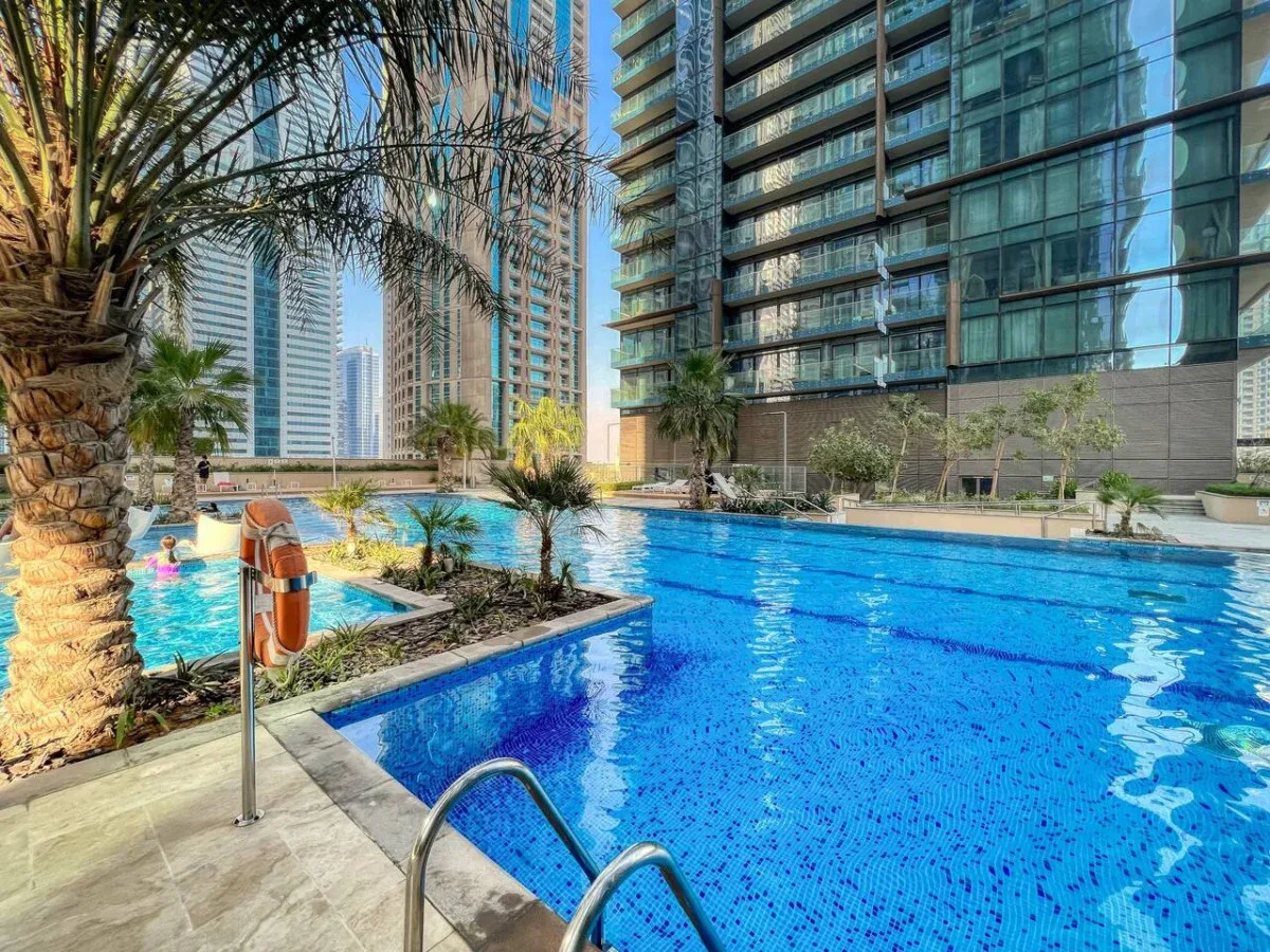 Una piscina al aire libre junto a modernos edificios altos.