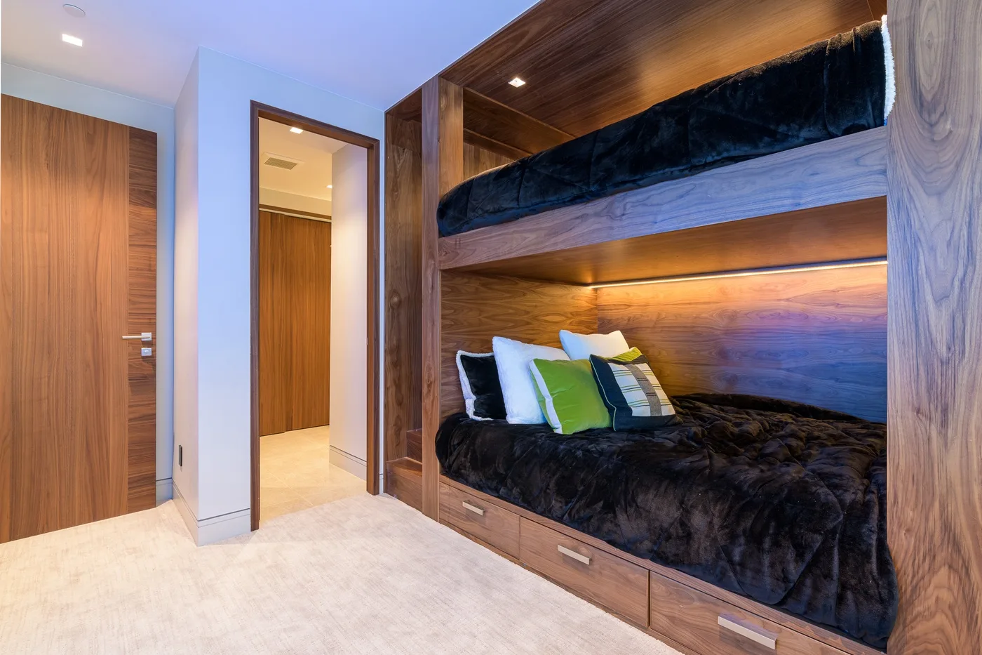 A bedroom with built-in bunk beds and colorful pillows.