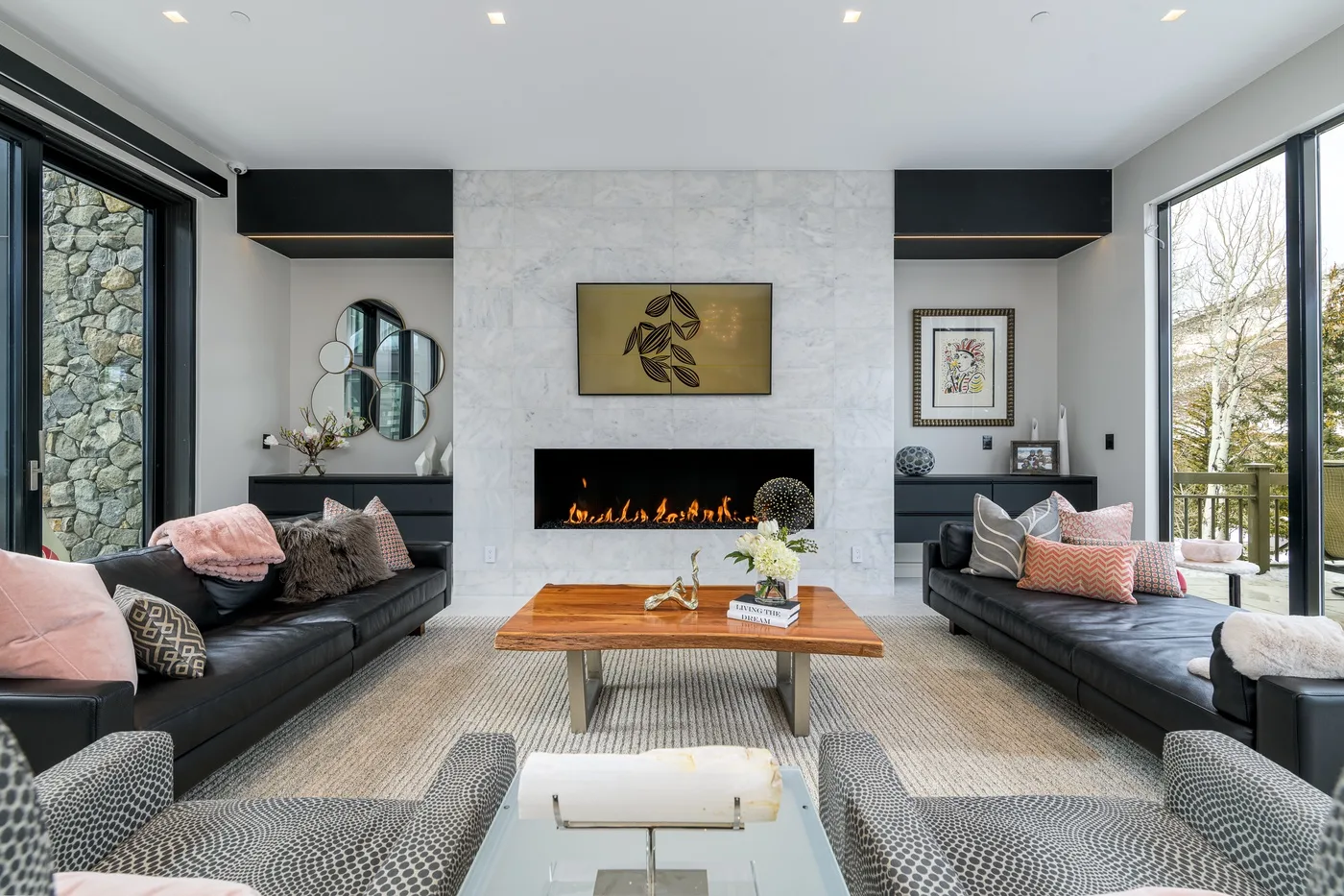 A living room with seating arranged around a coffee table and fireplace.