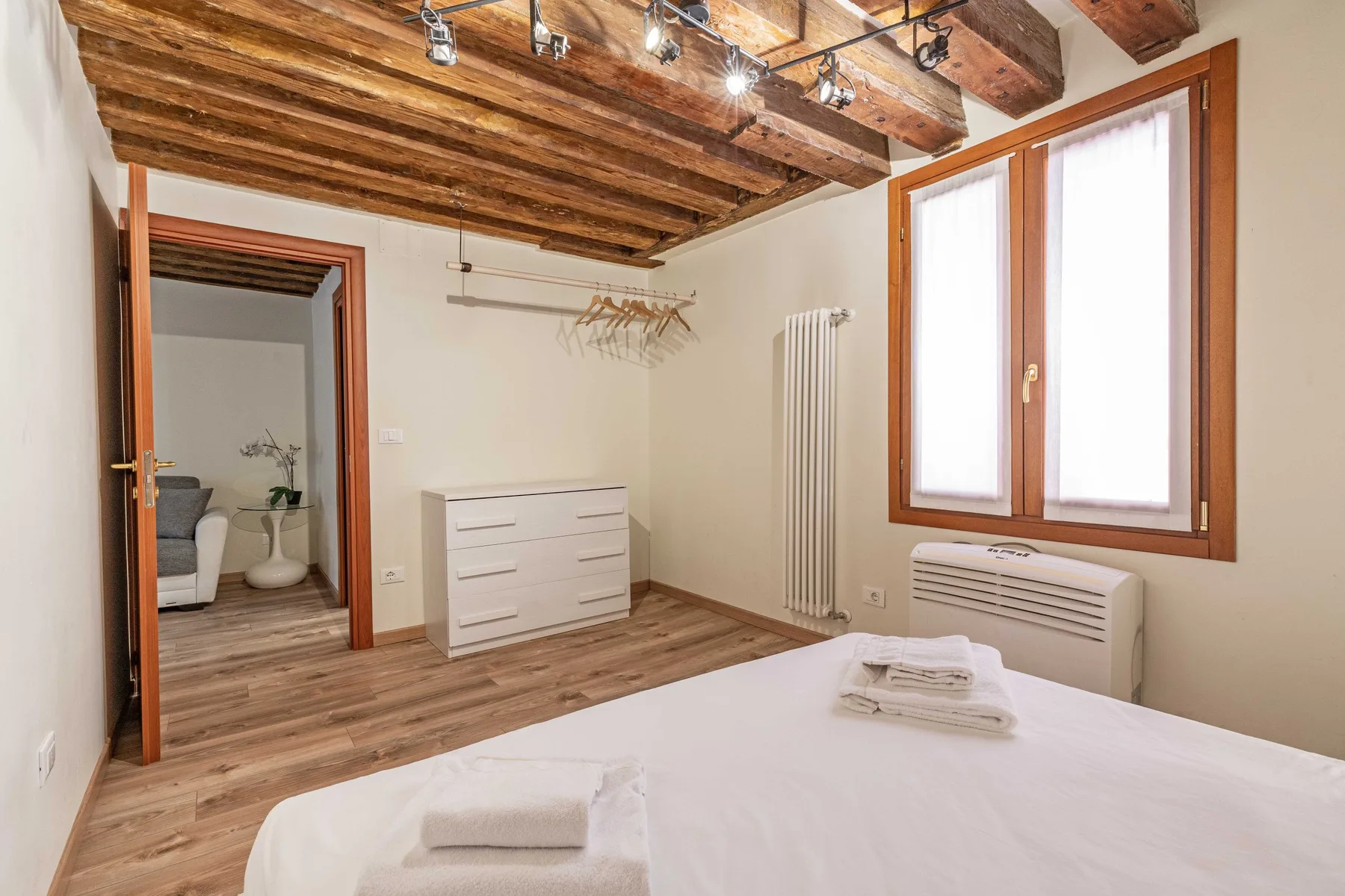 Un dormitorio con una cama, una cómoda y un techo de madera.