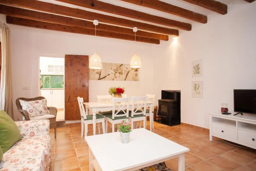 A living and dining area with seating, a dining table, and a television.