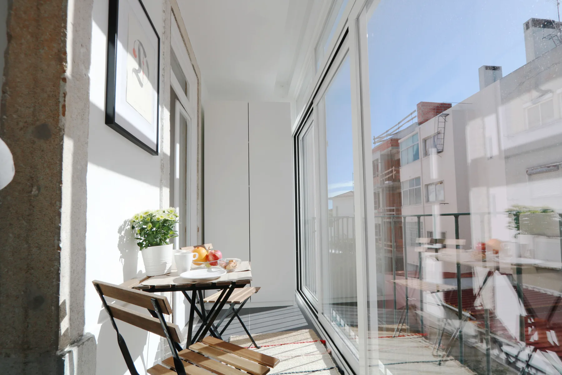 Un comedor luminoso con una mesa pequeña junto a grandes puertas de cristal.