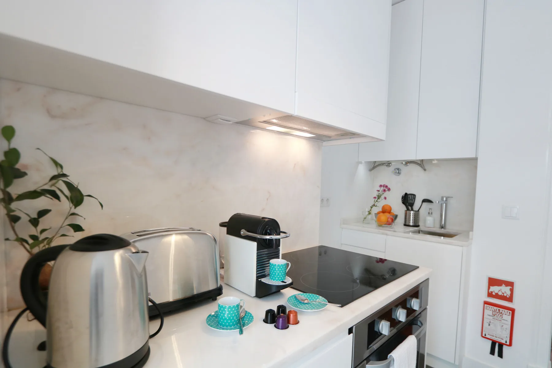 Una encimera de cocina luminosa con pequeños electrodomésticos junto a una estufa.