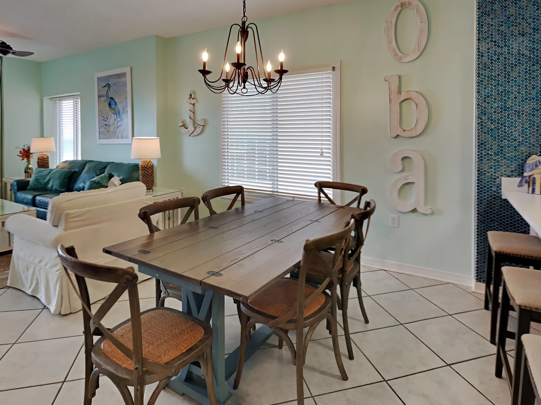 Comedor con una mesa de madera y sillas junto a una sala de estar.
