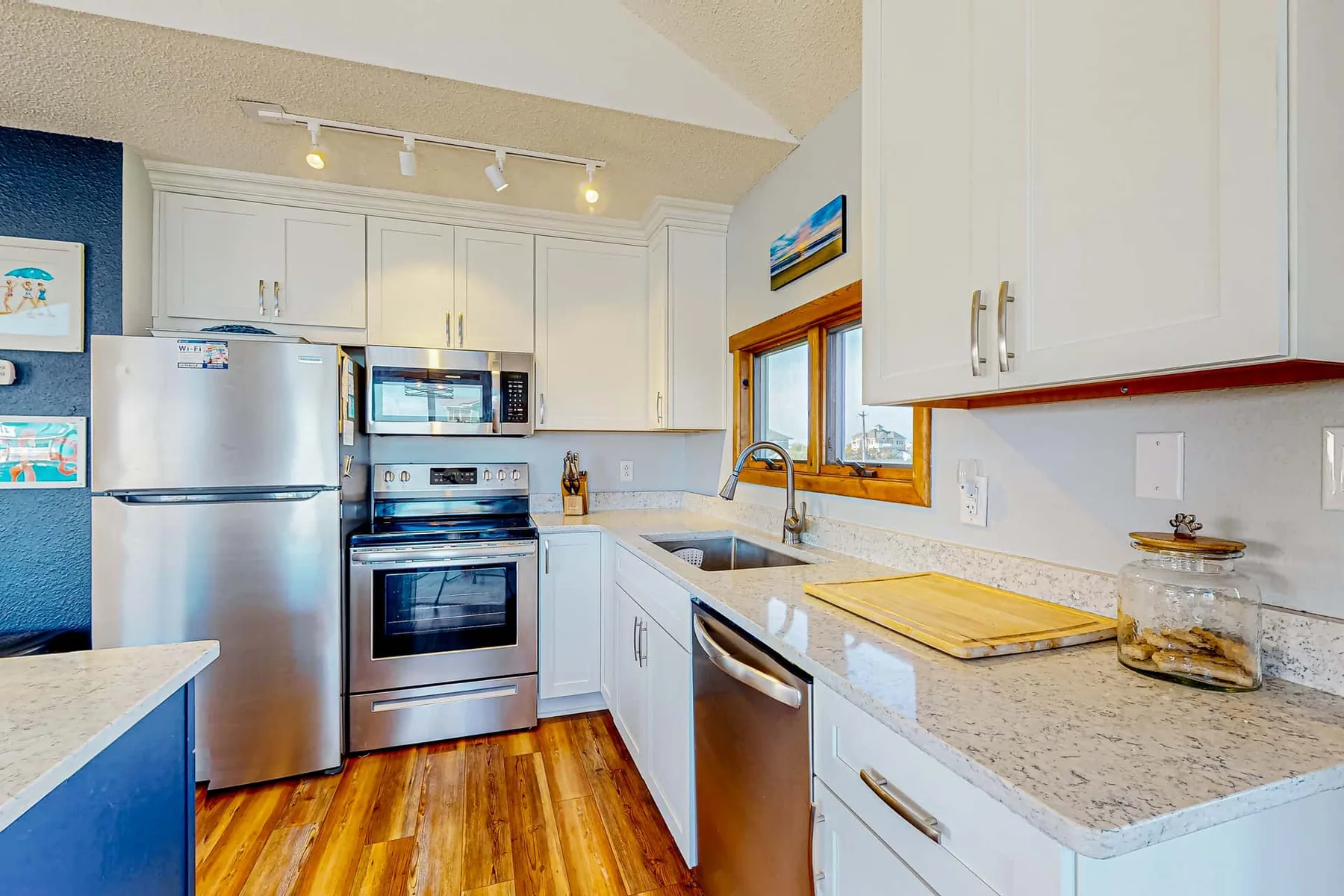 A bright kitchen with stainless steel appliances and white cabinets.