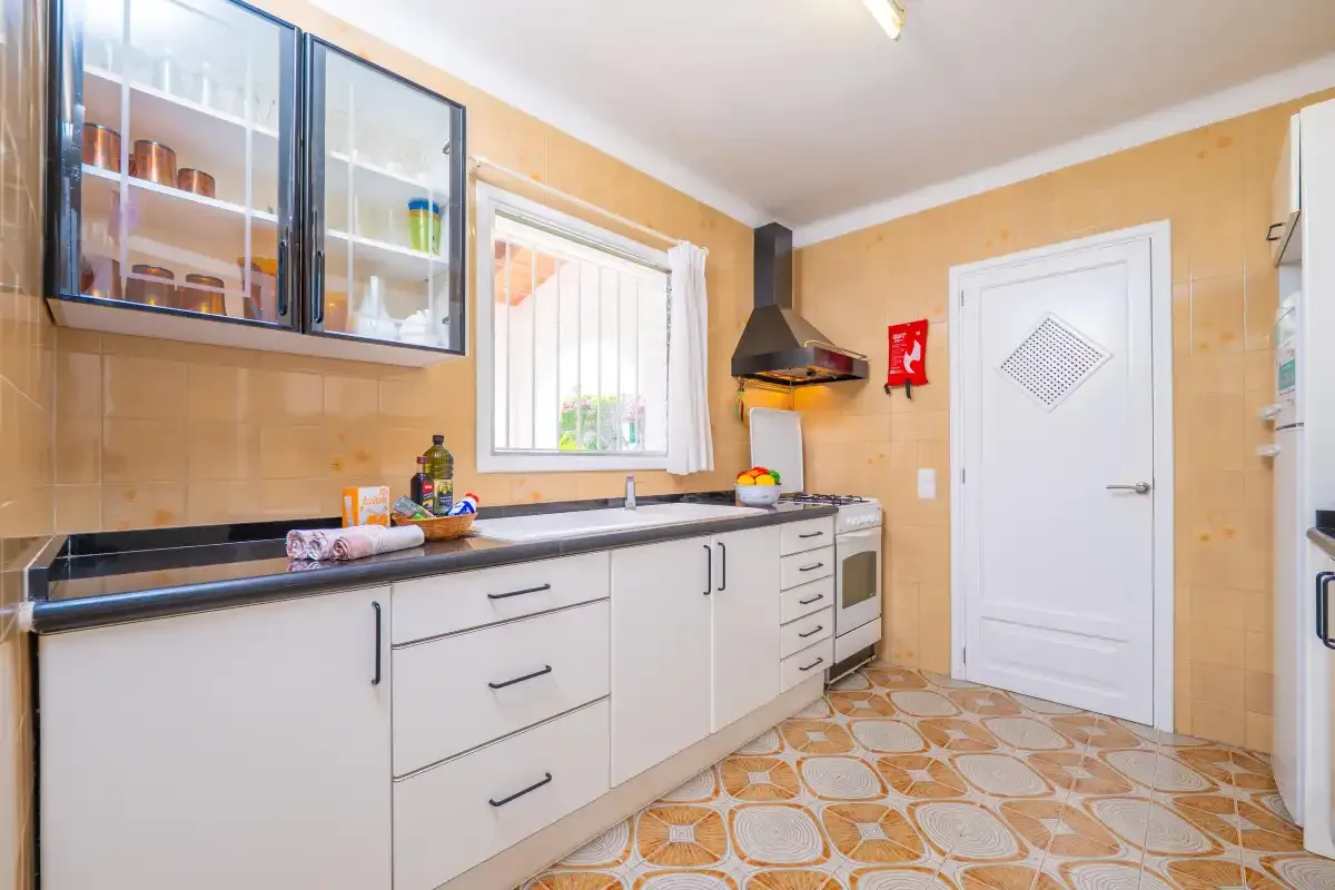 A kitchen with white cabinets, a countertop, and a window.