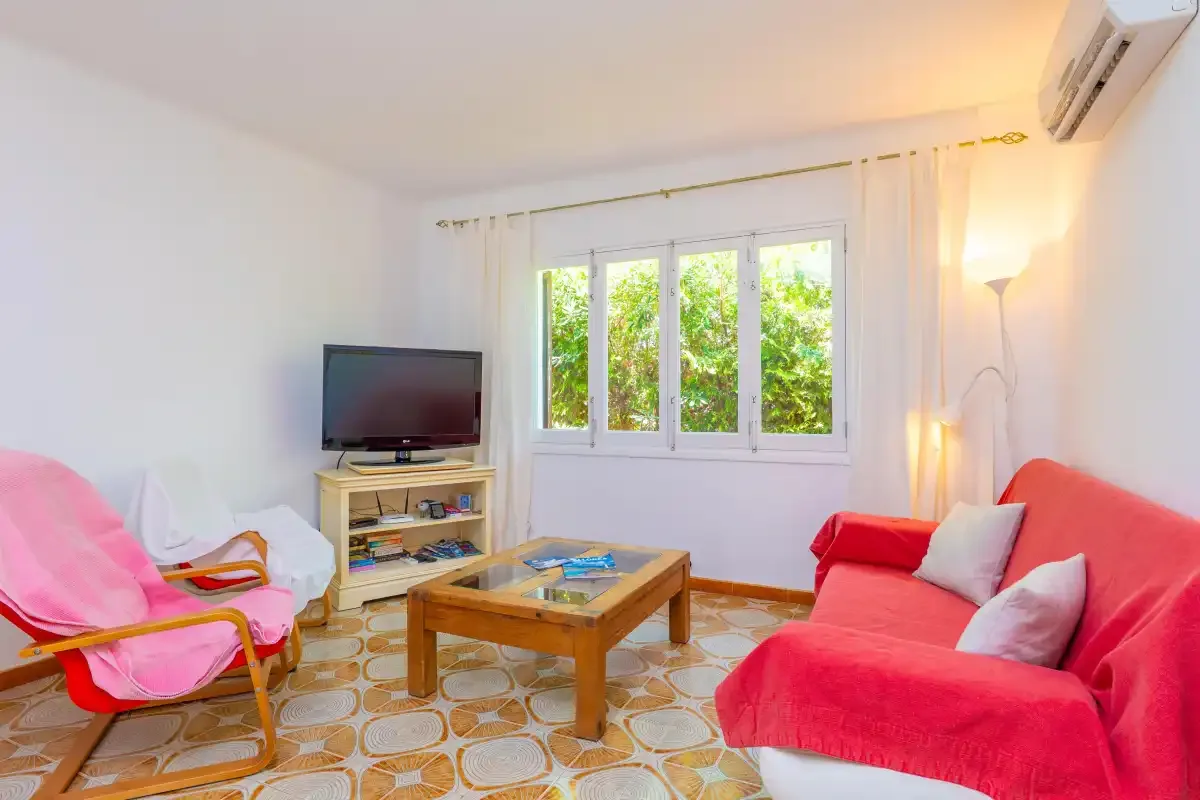 A bright living room with red seating and a wooden coffee table.