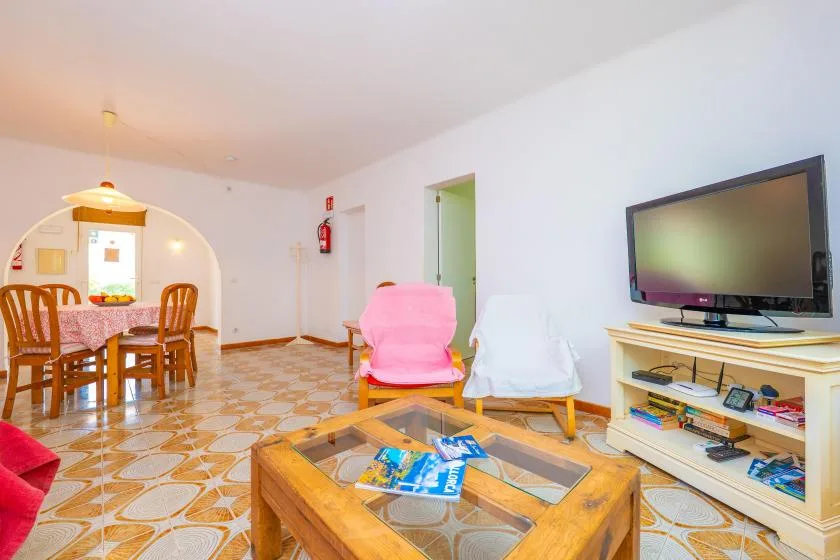 A living room with a television, seating, and a wooden coffee table.