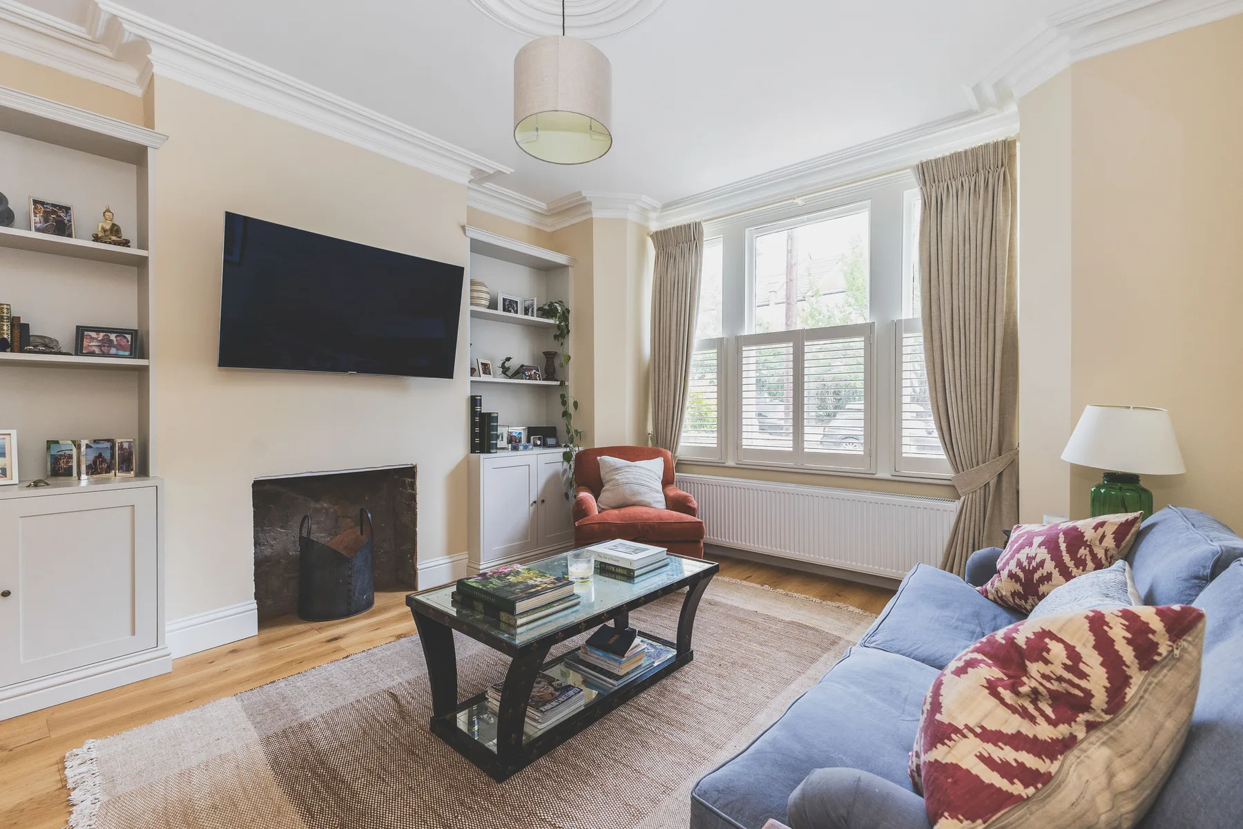 A living room with a blue sofa, coffee table, and fireplace.