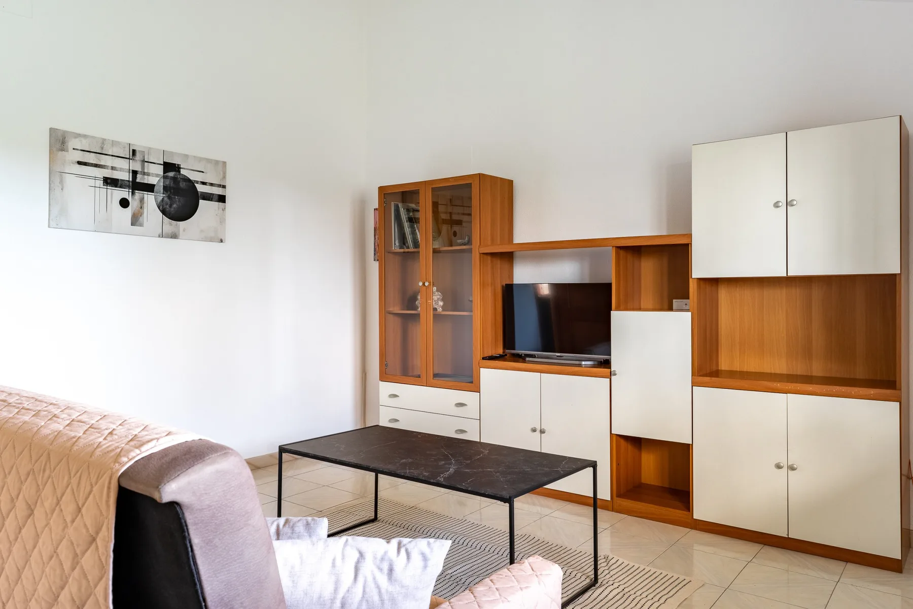 Una sala de estar con asientos, un televisor y armarios empotrados.