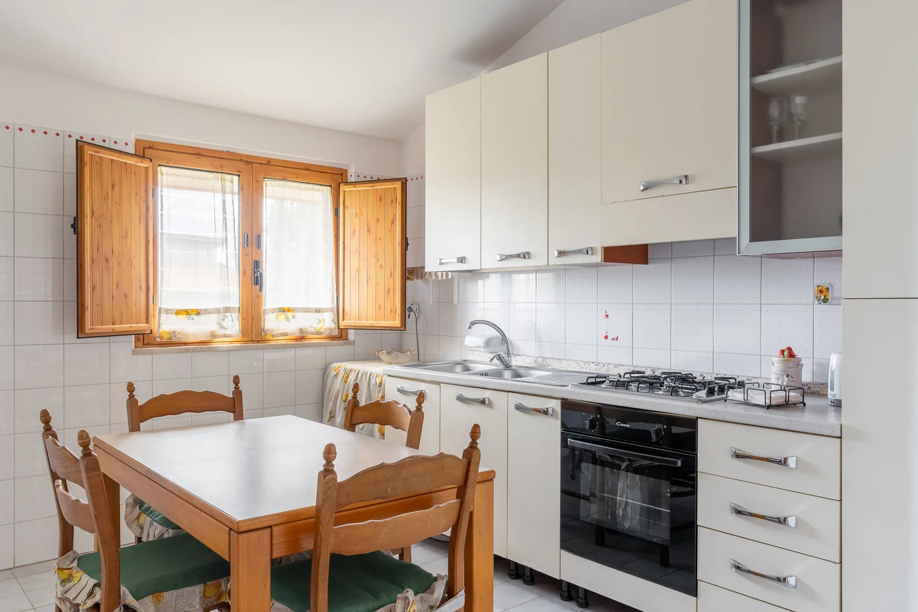 Una cocina y comedor con una mesa de madera junto a la encimera.