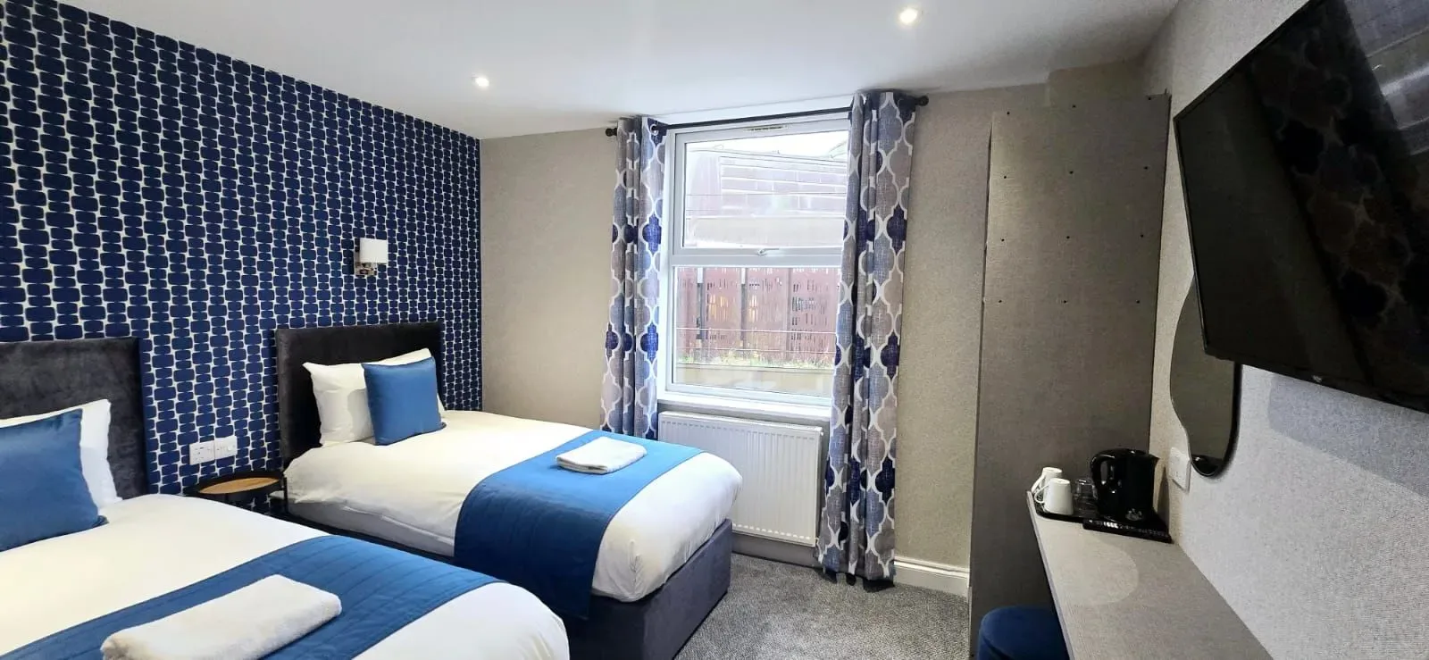 Una habitación de hotel con dos camas y persianas azules.