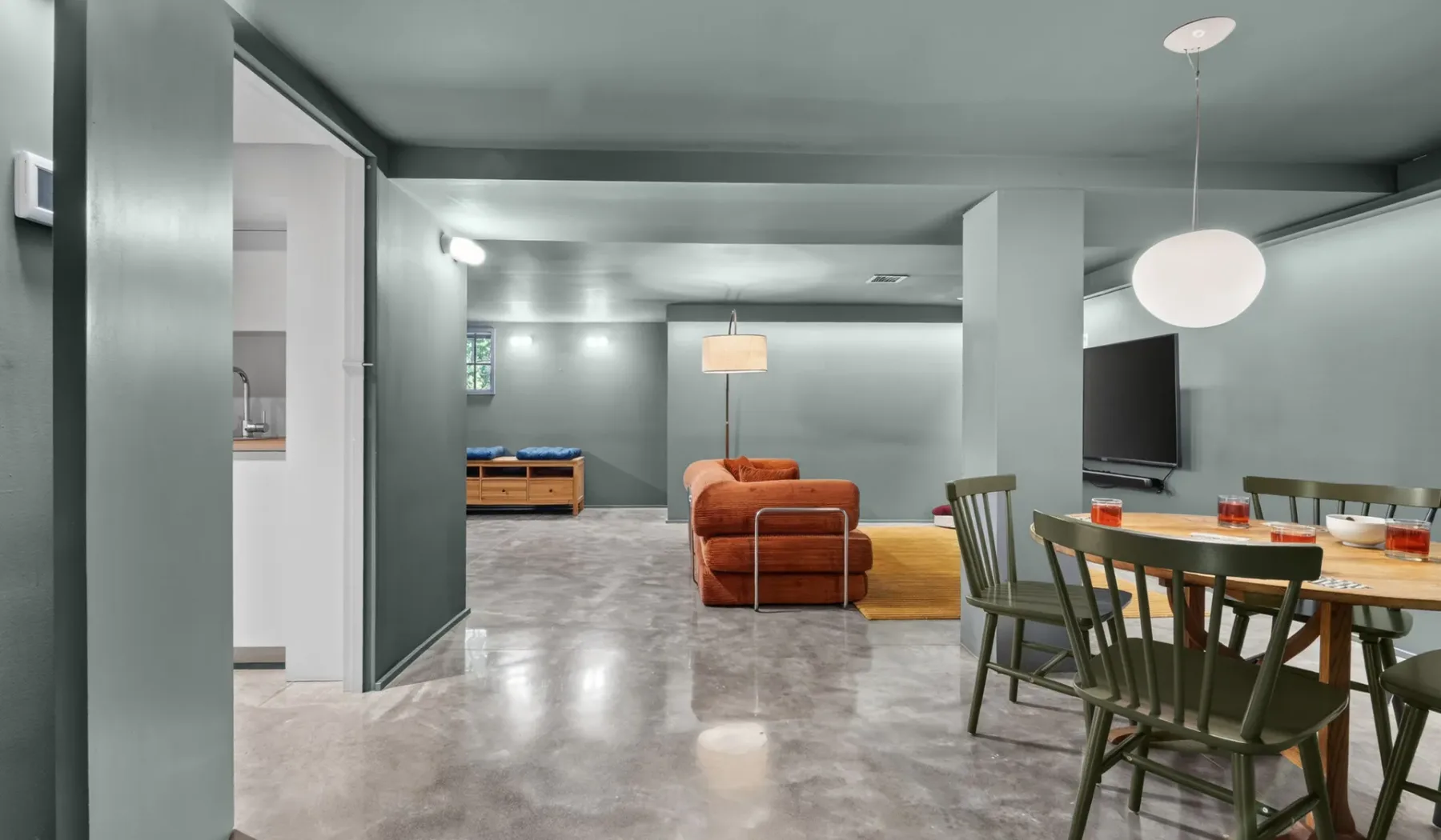 Una sala de estar y comedor de planta abierta con asientos alrededor de una mesa.