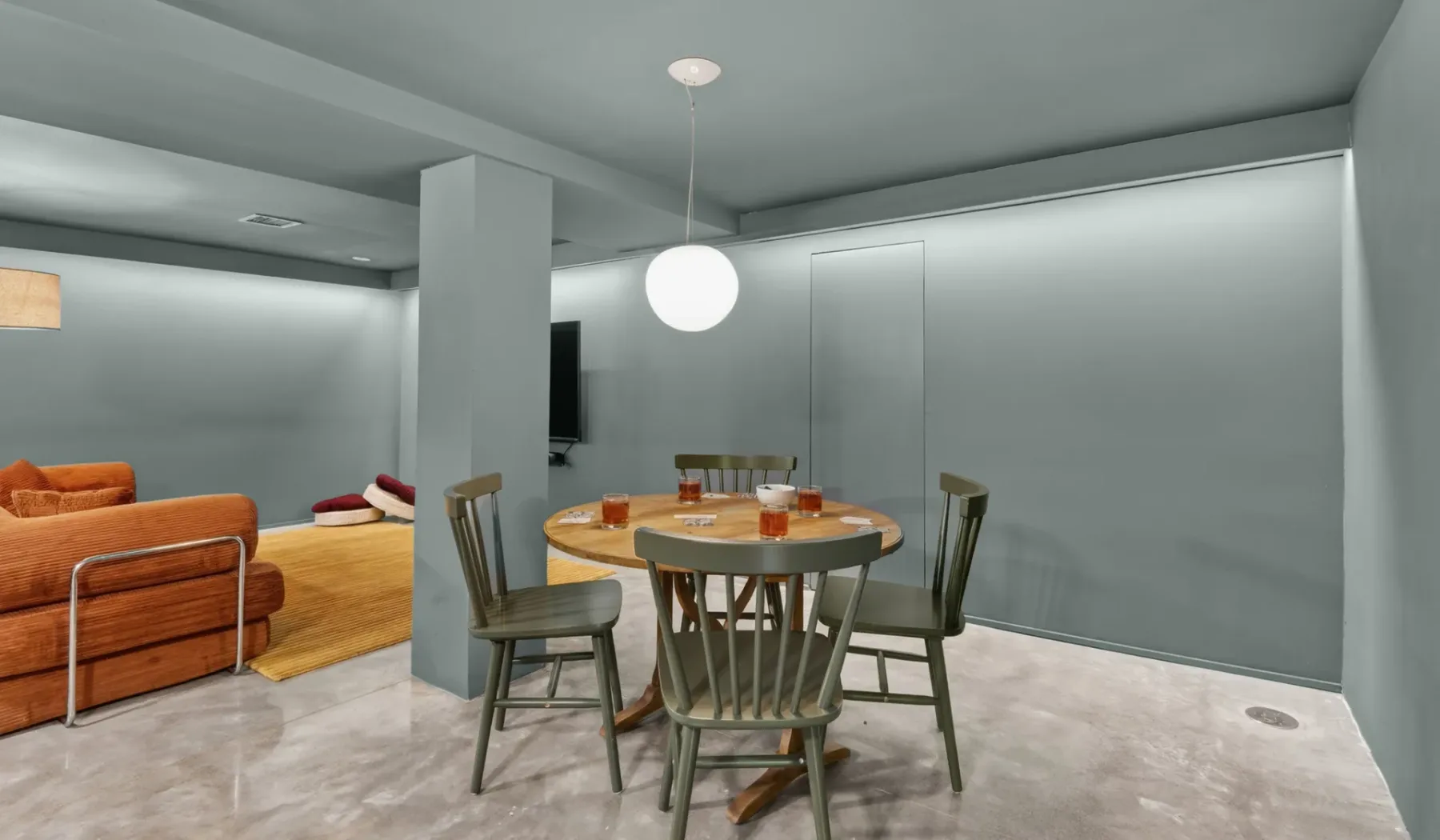 Comedor con una mesa redonda y sillas junto a una sala de estar.